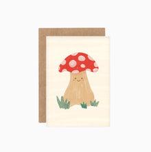 A cute illustrated greeting card featuring a smiling mushroom with a red cap, attached to a brown Kraft envelope, against a white background.