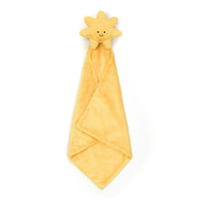 A plush toy in the shape of a sun with a smiling face, wrapped in a soft, yellow blanket with a Baby Jellycat grosgrain ribbon.