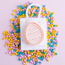 An eco-friendly playdough stamp with an egg waves design is displayed on a background of multicolored playdough beads, with the brand 'PLAY SENSE' visible on the top left.