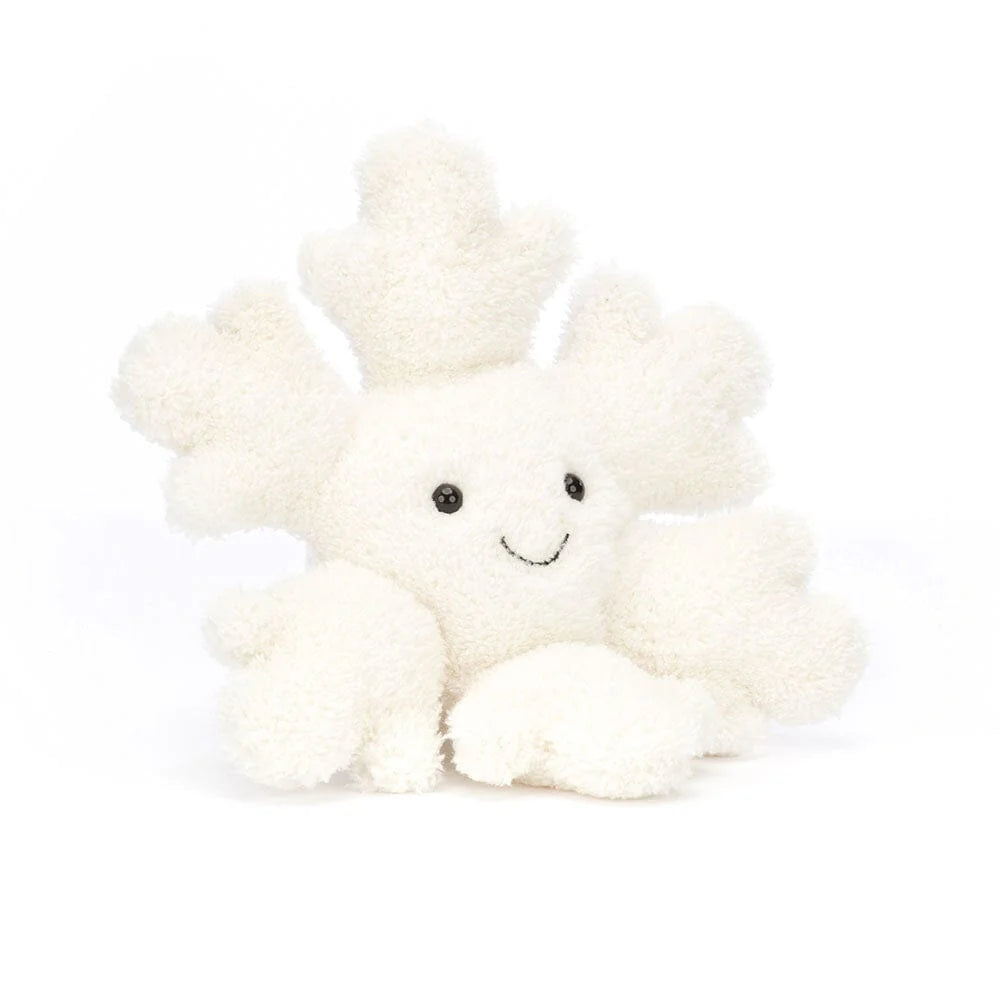 A plush toy resembling a snowflake with a smiling face and fluffy cream-colored branches.
