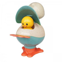 A multicolored plastic toy resembling a chicken with a pop-up head and a baby chick inside, with orange feet and a blue body.