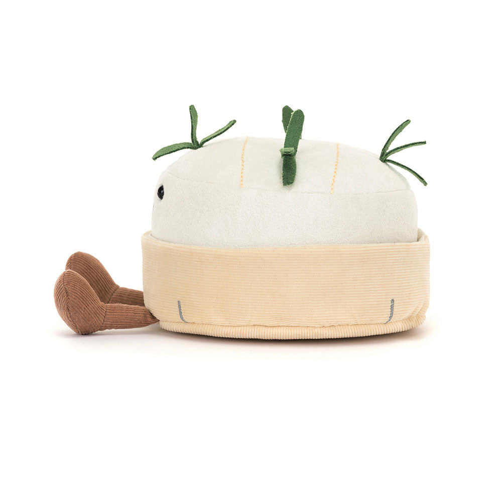 Plush toy shaped like a block of camembert cheese with green herbs  on a white background