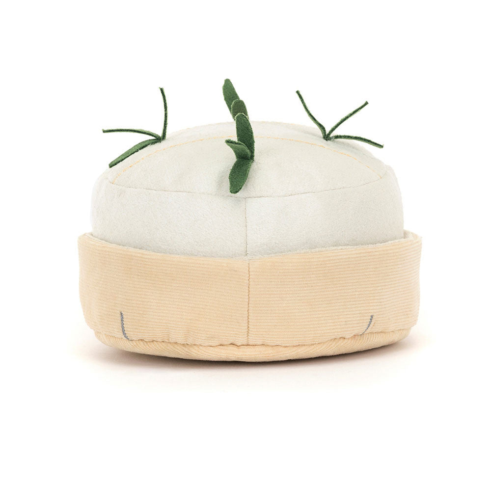 White plush toy shaped like a block of camembert cheese with green herbs on a white background