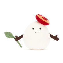 Plush toy resembling a mozzarella cheese ball  with a smiley face and tomato hat on a white background
