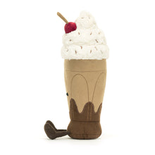 A soft toy representing a chocolate sundae drink with whipped cream, sprinkles and a cherry on top.