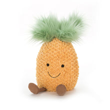 A plush toy resembling a pineapple with a green top, brown feet, and a smiling face.