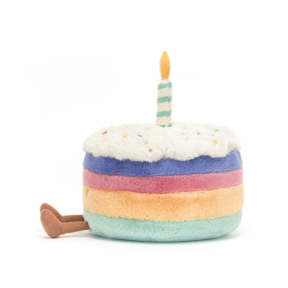 Stuffed toy resembling a birthday cake with a candle on a white background