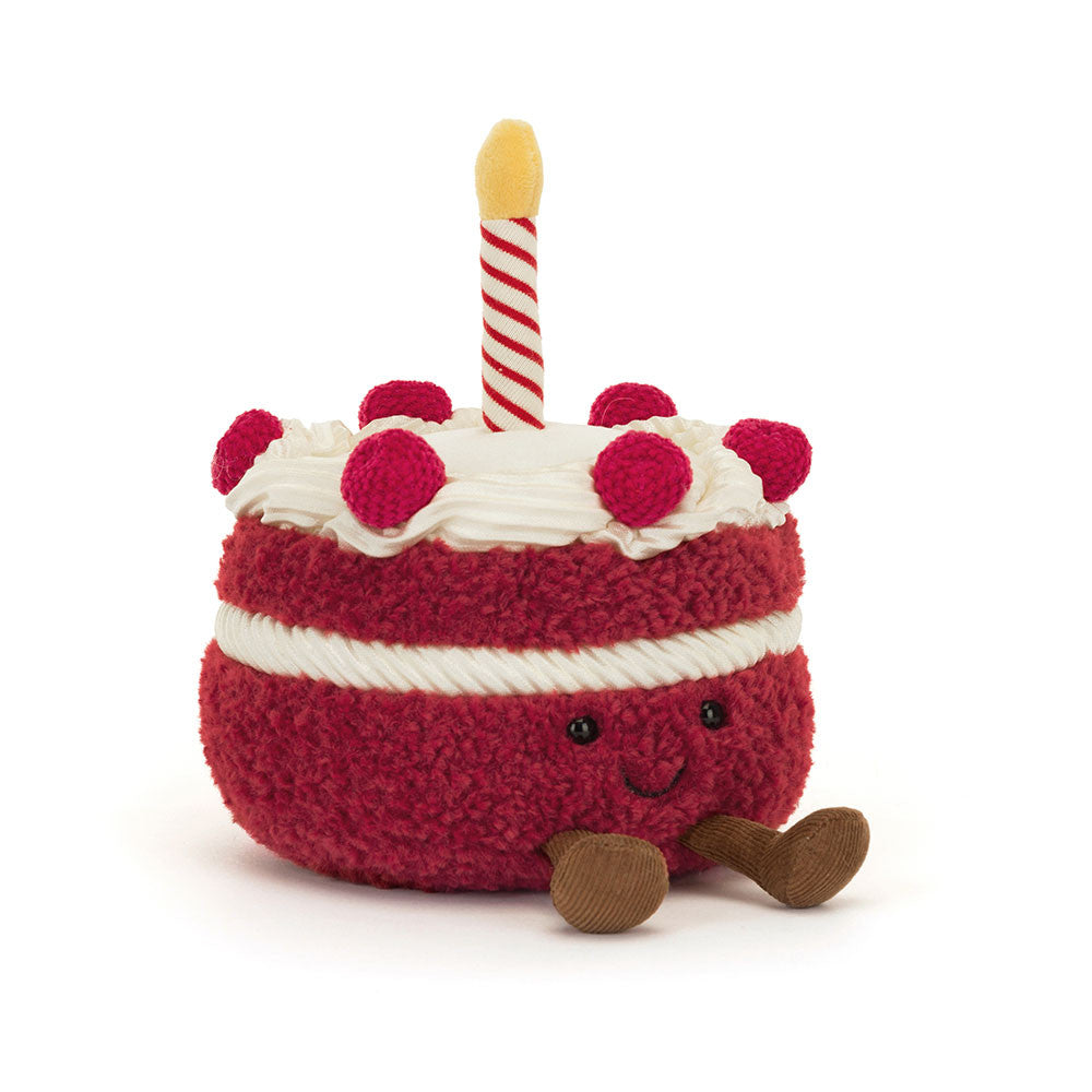 Jellycat red cake plush toy with white frosting and a candle on a white background