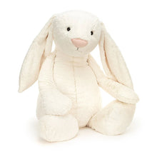 A large plush toy bunny with cream-colored fur, long ears, and a pink nose.