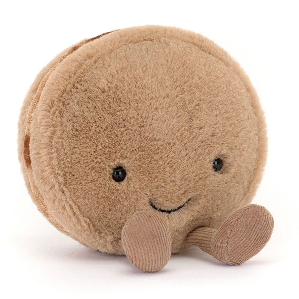 Round Jellycat plush toy resembling a macaron with a smiling face on a white background