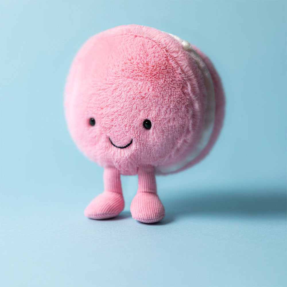 Pink plush toy with a smiley face on a light blue background