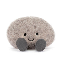 Plush toy resembling a round grey pebble with a smiling face on a white background