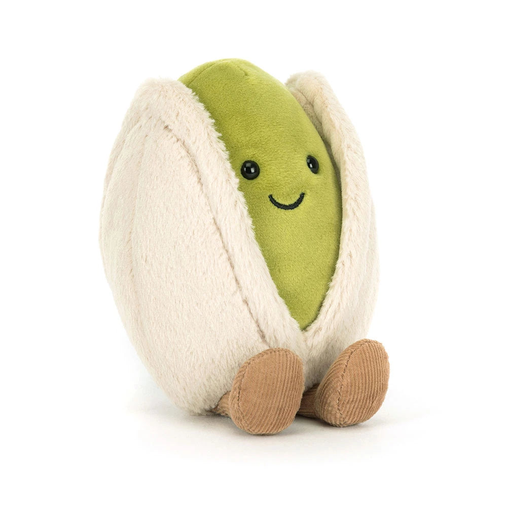 Plush toy shaped like a pistachio with a smiling face on a white background
