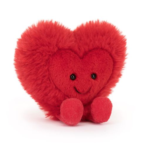 Fluffy red soft toy made by Jellycat in the shape of a heart. The heart has a smiling face and red plush legs.