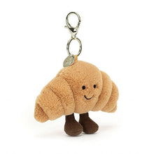 Plush bag charm shaped like a croissant on a white background