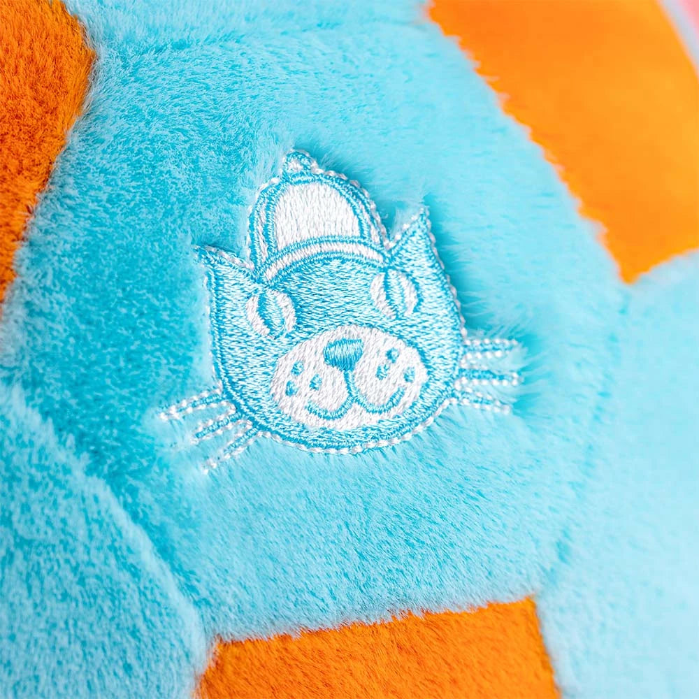 Close-up of a plush toy with an embroidered Jellycat logo  on a blue and orange background