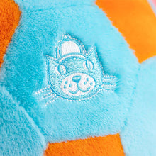 Close-up of a plush toy with an embroidered Jellycat logo  on a blue and orange background