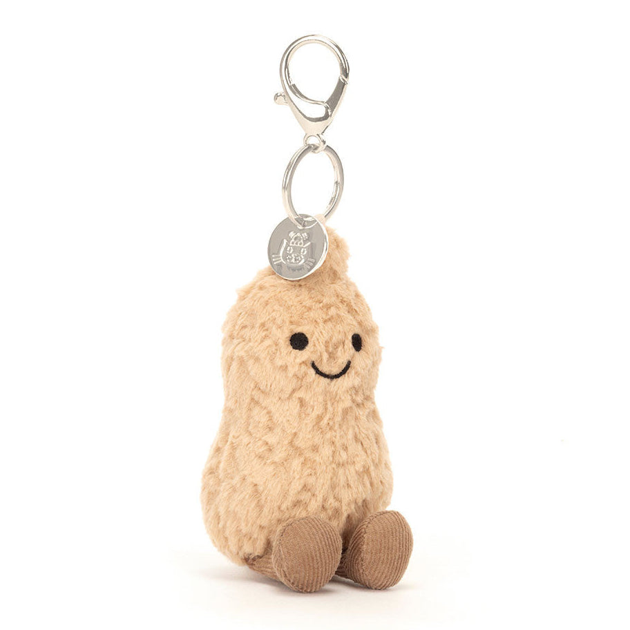 Jellycat Plush keychain shaped like a peanut with a smiling face on a white background