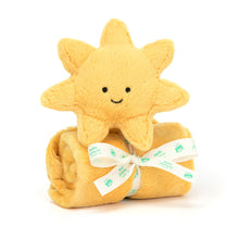 A plush toy in the shape of a sun with a smiling face, wrapped in a soft, yellow blanket with a Baby Jellycat grosgrain ribbon.