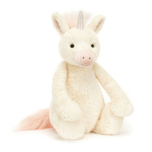 A large plush toy unicorn with soft vanilla fur, detailed with a strawberry-sundae nose and ears, and a squashy holographic horn.