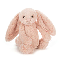 A small plush toy resembling a blush pink bunny with long ears, designed for cuddling.