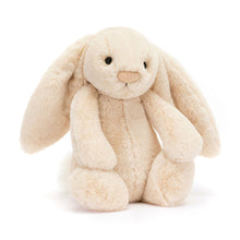 A plush toy resembling a beige bunny with long ears, a round face, and a small nose with a sparkle detail.