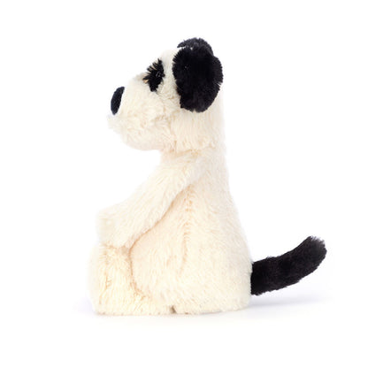 Plush toy dog with black ears and tail on a white background