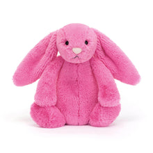 A soft, hot pink stuffed bunny toy with a round nose and big eyes, made of plush fabric.