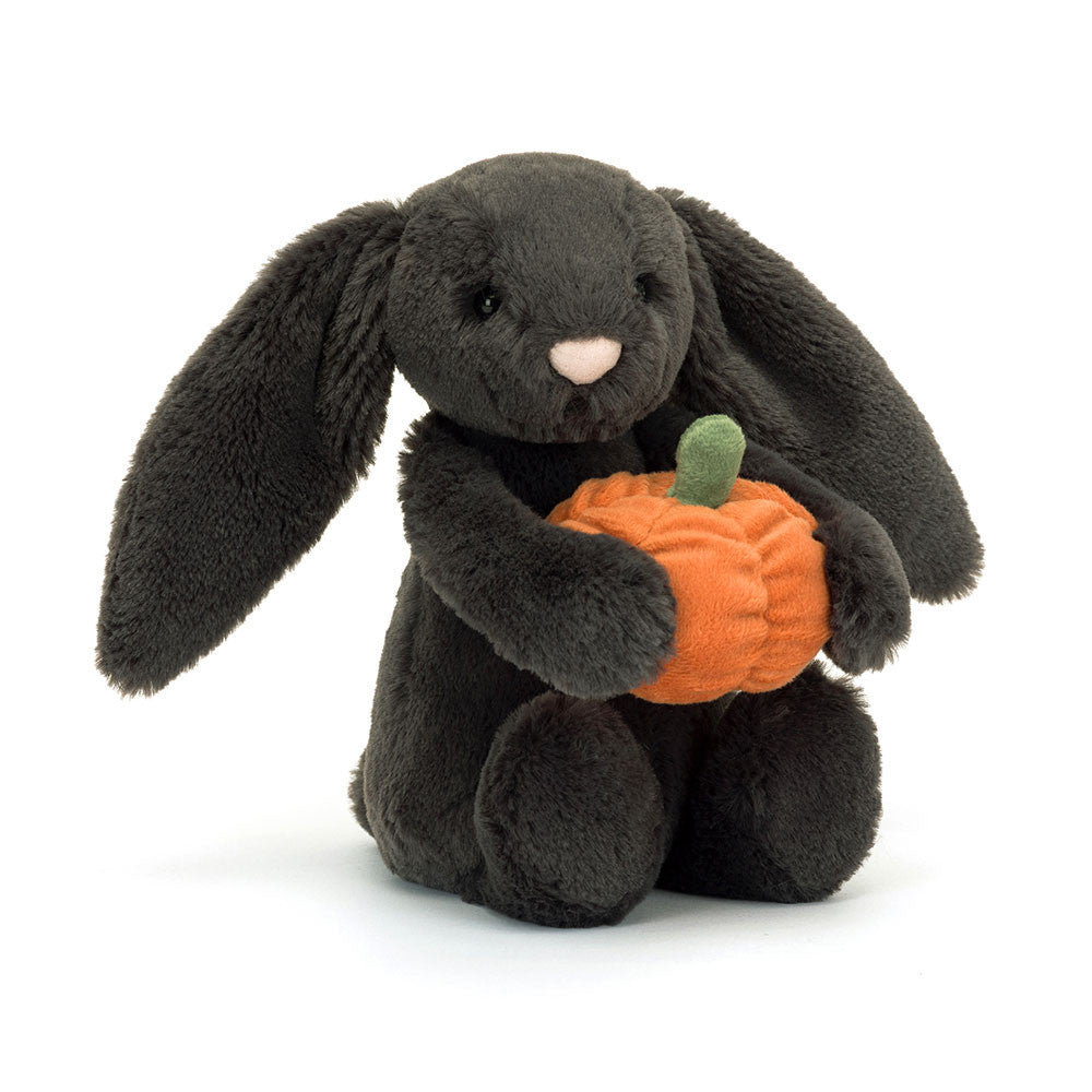 A plush toy depicting a brown bunny holding an orange pumpkin with a green stem.