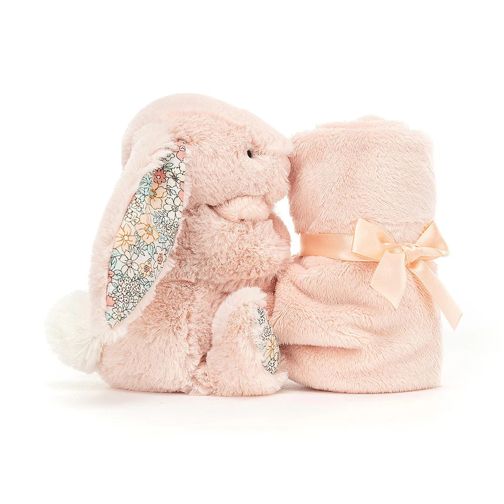 A blush pink Jellycat soother with a plush bunny attached to a floral-patterned blanket, wrapped with a pink ribbon.