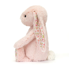 A small plush toy resembling a bunny with blush-pink fur, floral ears, and feet, set against a plain background.