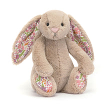 A beige plush toy rabbit with floral patterned ears and feet.