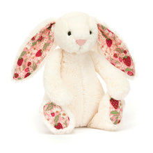 A small plush toy resembling a cream-colored bunny with strawberry patterns on the ears and feet, set against a plain background.