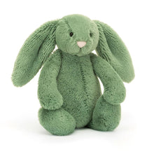 A soft green plush toy resembling a bunny with long ears, a pink nose, and chunky paws.