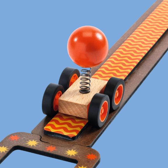Toy car with a spring and red ball on a blue background