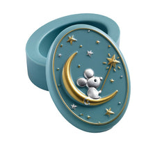 A small oval-shaped teal resin tooth keeper box with a 3D illustration of a mouse sitting on a moon, surrounded by gold and silver stars.