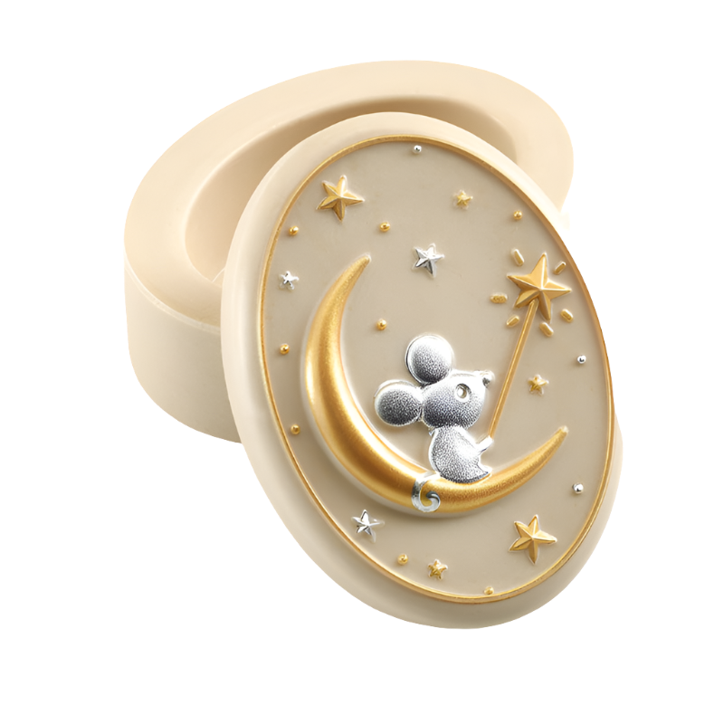 A small, oval-shaped beige resin tooth keeper box with a 3D illustration of a mouse on the moon design, surrounded by gold and silver stars.