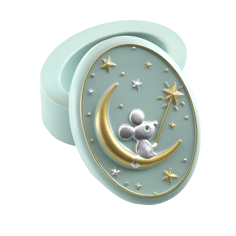 A small, oval-shaped mint green resin tooth box with an illustration of a 3D mouse sitting on the moon, surrounded by gold and silver stars.