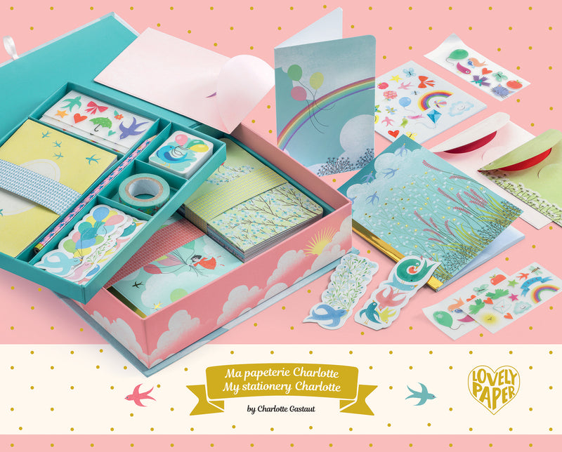 A box set of children's stationery with pink and blue cloud design, including various cards and envelopes with decorative elements.