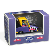 A toy car with a shark design, predominantly purple, with a yellow roof, packaged in a box labeled 'Shark N Go, Crazy Motors'.