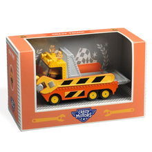 A toy tow truck with a large sliding platform, placed in an orange box with an open lid showing the product inside. The truck is primarily yellow with black and orange details.