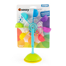 A colorful toy resembling a flower with a spinning wheel in the center and petals in various colors, designed for water play. The toy s attached to a cardboard retail pack, printed with SASSY.