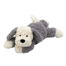 A soft, plush sheep dog toy with gray and cream fur and a velvety black nose, lying down.