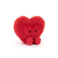 Fluffy red soft toy made by Jellycat in the shape of a heart. The heart has a smiling face and red plush legs.