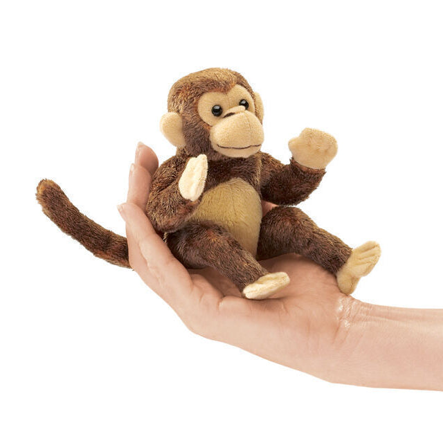 Stuffed monkey toy held in a hand on a white background