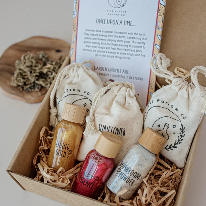 A potion making kit labeled with different plant names, presented in a wooden box with each ingredient enclosed in its own small fabric bag. The box is titled 'Gnome Remedy'.