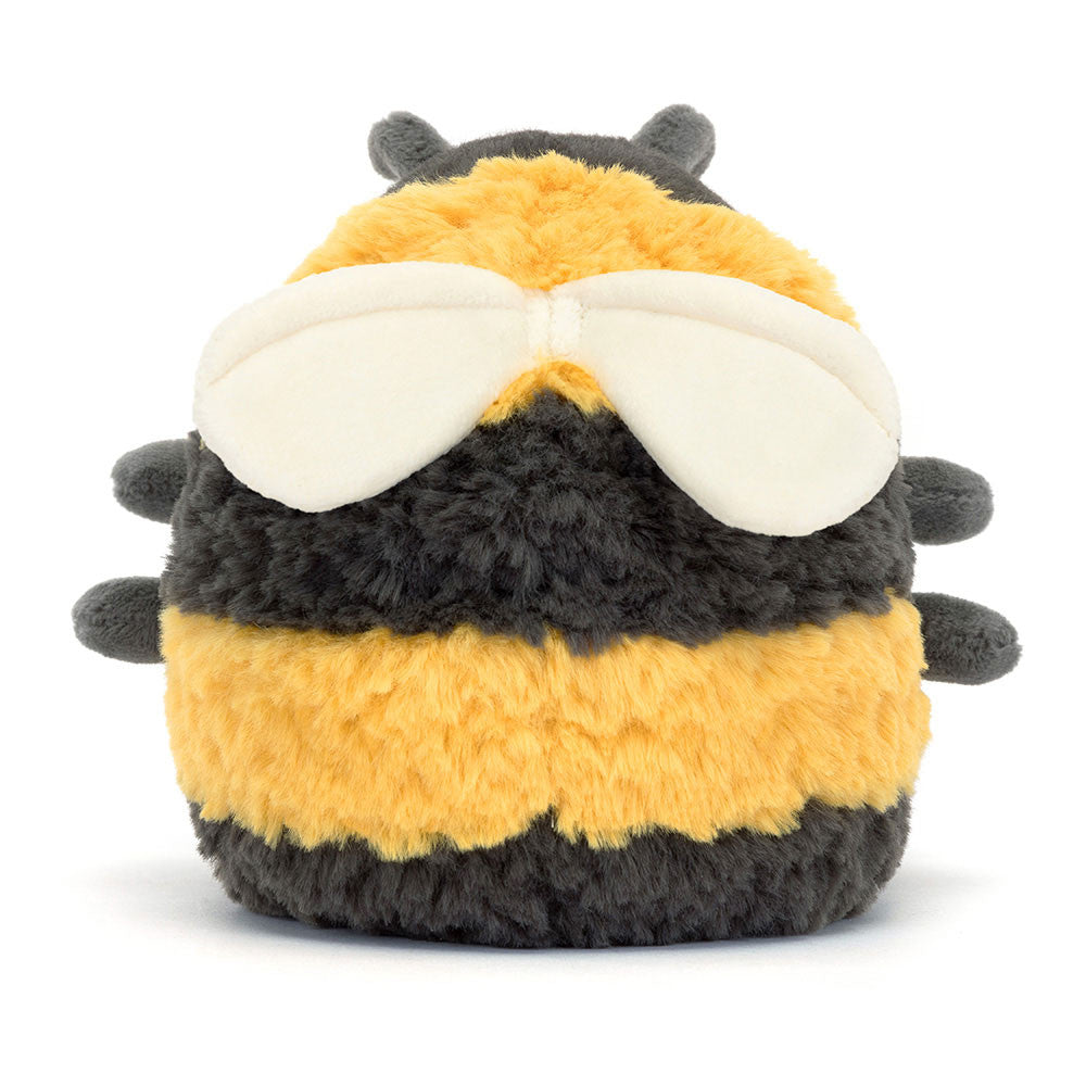 A plush toy resembling a bumblebee with thick yellow and black striped fur, charcoal legs, and soft cream wings.
