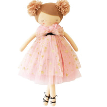 A strawberry blonde, soft-bodied doll with a ballet-style dress adorned with gold stars and delicate face details, standing on two legs.