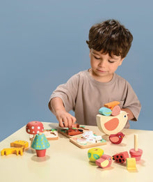 Child playing with colorful wooden toys on a table against a blue background