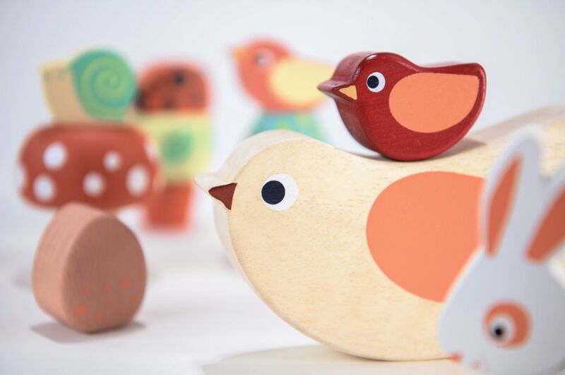 Wooden toys including a bird, rabbit, and snail on a light background